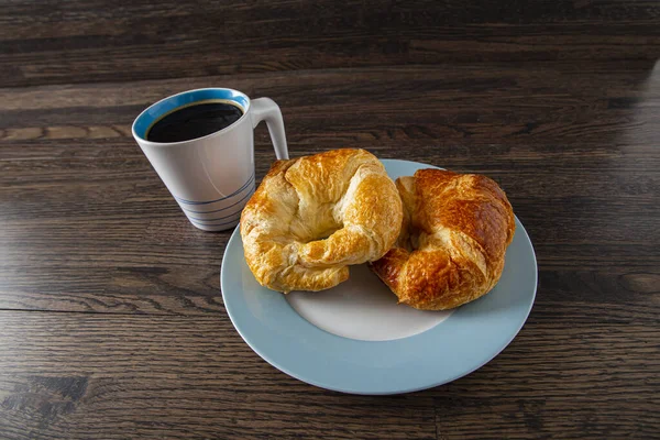 Dois Croissants Uma Placa Aros Azul Com Café Preto Contra — Fotografia de Stock