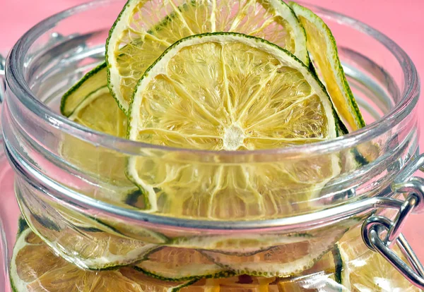 Dried lemons and limes in an electric dryer in a glass jar