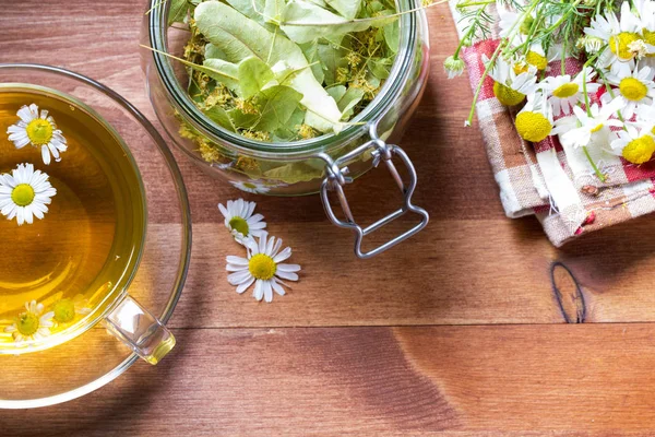 Tea herbs healing chamomile wooden background