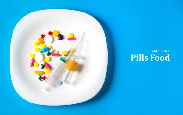 Pills food concept of antibiotic eating harm , blue background medical blue plate
