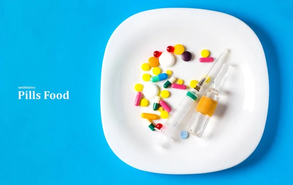 Pills food concept of antibiotic eating harm , blue background medical blue plate