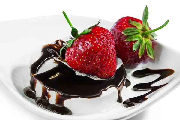 Erdbeeren auf einem Eis, das von Schokolade auf einem weißen Blatt geträufelt wird — Stockfoto
