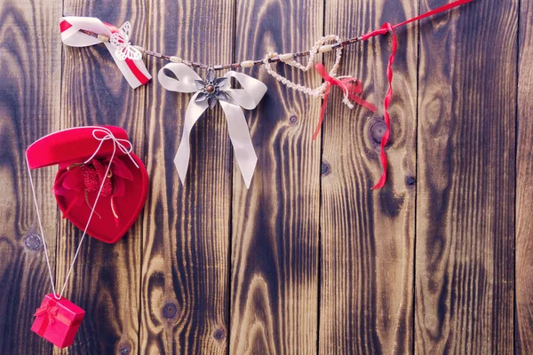 Corazón rojo, regalo, arco blanco y cintas colgando de una cuerda —  Fotos de Stock