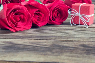 ahşap arka plan üzerinde hediye ve kırmızı güller