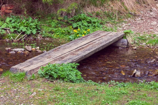 Wooden crossbar over a stream — Stock Photo, Image