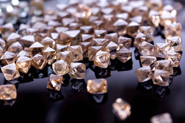 Přírodní transparentní diamanty v makru s žlutým reflexe na černém pozadí — Stock fotografie