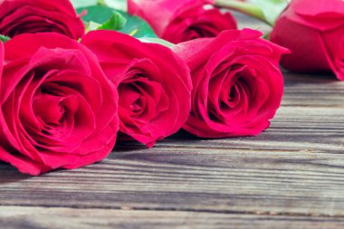 ahşap arka plan üzerinde kırmızı üç gül