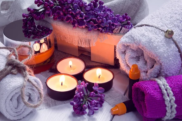 SPA consistem de toalhas, lilás, velas, creme e óleo — Fotografia de Stock