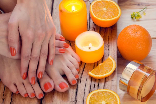 Pomarańczowy manicure wokół pomarańcze i świece — Zdjęcie stockowe