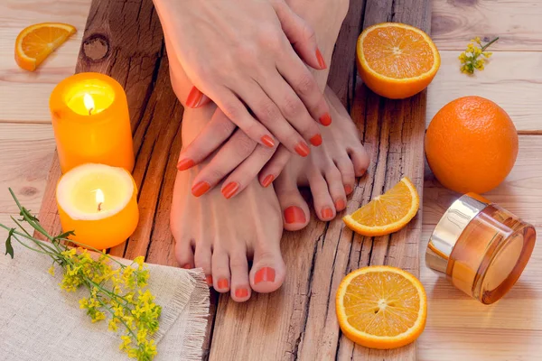 Oranje manicure rond sinaasappelen en kaarsen — Stockfoto