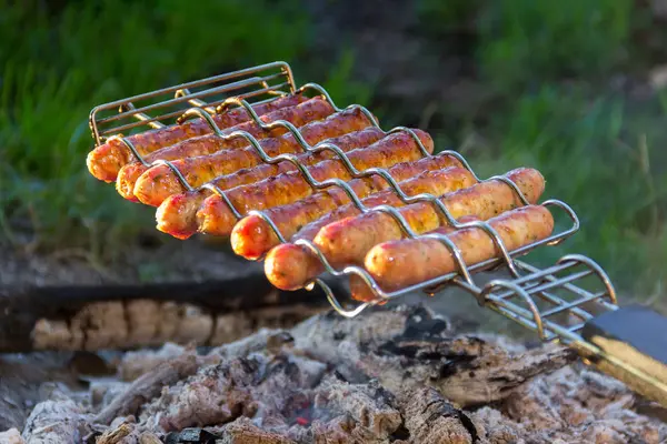 Salsichas fritas em uma fogueira — Fotografia de Stock