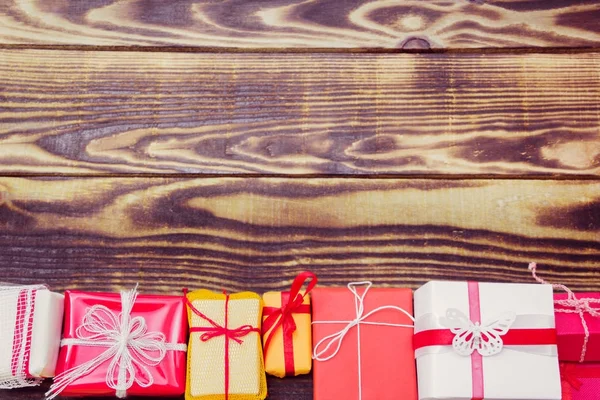 Geschenken in een verschillende pakketten op een houten achtergrond — Stockfoto