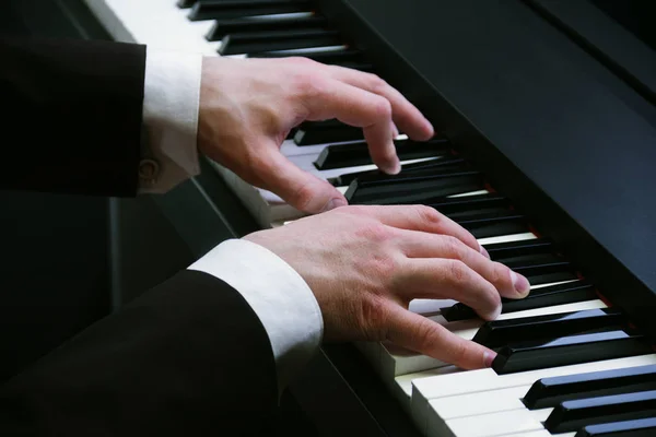 Manos de hombre tocando un piano en el concierto — Foto de Stock