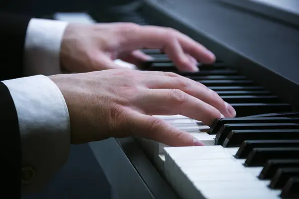 Manos de hombre tocando un piano en el concierto — Foto de Stock