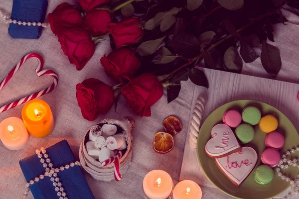 Cena con velas y rosas rojas y regalos —  Fotos de Stock