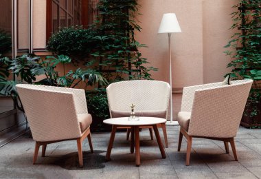 Evin arka planında saman ve meşaleden yapılmış koltuklar ile rahatlamak için bir yer