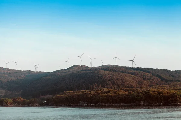 Alternative Energy Wind Turbines Bergen Een Zee Blauwe Lucht Achtergrond — Stockfoto