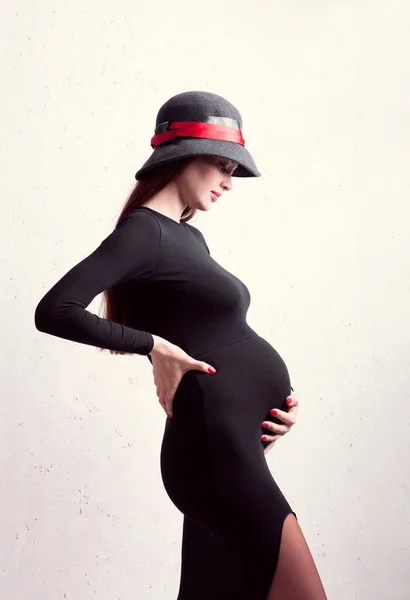 Zwanger Meisje Gekleed Zwarte Jurk Hoed Houdt Zichzelf Buik — Stockfoto
