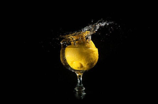 Lemon splashing into glass