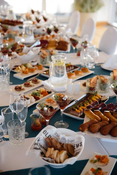 Cibo servito sul tavolo in una sala bianca durante una festa di compleanno in Europa orientale Baltico Riga Lettonia - Colori blu e verde acqua - Canape, snack e bevande leggere — Foto Stock