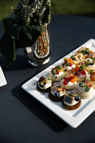 Comida servida em mesa redonda em um salão branco durante uma festa corporativa de aniversário na Europa Oriental Báltico Riga Latvia - Sala de ambar de madeira em estilo rural - Canapé, lanches e bebidas leves — Fotografia de Stock