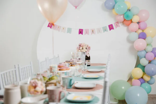 Еда подается на стол в белом зале во время празднования дня рождения детей в Восточной Европе Балтийская Рига Латвия - Мягкая осада, крем, розовые цвета - Канапе, закуски и легкие напитки — стоковое фото