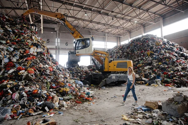 Doğayı kirletme eylemcisi - genç sarışın kadın - Doğu Avrupa 'da Letonya Riga' da arka planda faaliyet gösteren tüm insan atıklarına ve plastiklerine bakıyor