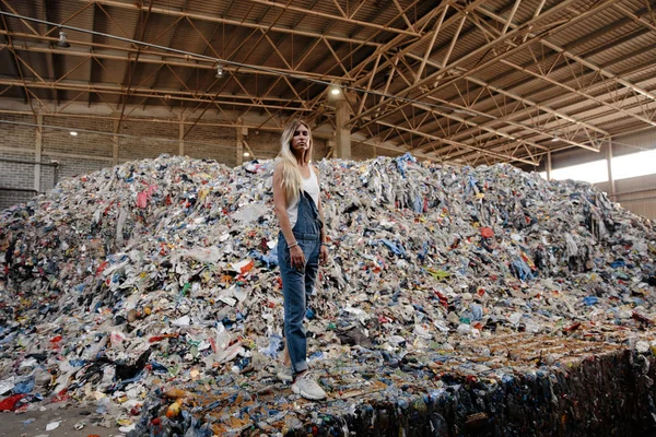 Büyük bir çöplükte doğa kirliliği aktivisti genç sarışın kadın Doğu Avrupa 'daki Letonya Riga' daki tüm insan atıklarına ve plastiklerine bakıyor.
