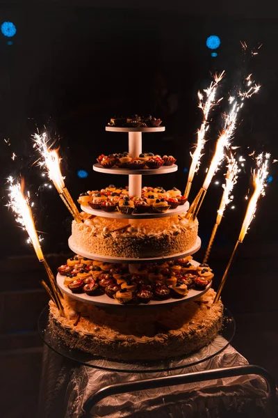 Фейерверк свечи: Свадебная вечеринка огромный многоэтажный торт, который состоит из кексов тоже в Восточной Европе Латвия Рига — стоковое фото