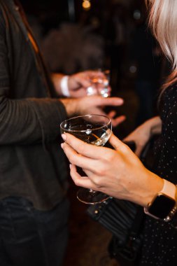 İnsanlar, Doğu Avrupa 'daki Letonya Riga Kafe Restoranı' nda bir Vip işletme etkinliğinde şampanya içecekleri ve telefonlarıyla sohbet ediyorlar.