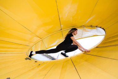 Gün batımında Riga nehri Daugava yakınlarında ısınan ve egzersiz yapan zayıf bir kadın - Şehir sağlığı konsepti - Doğu Avrupa Letonya Riga