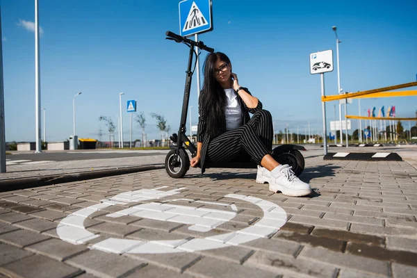 Otoparkta elektrikli scooter 'ın üzerinde oturan iş kadını, ücretsiz eko-dost ulaşımı. — Stok fotoğraf