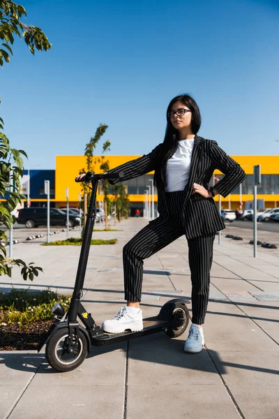 Affärskvinna sitter på elcykel på parkeringen - Utsläppsfri miljövänlig transport — Stockfoto