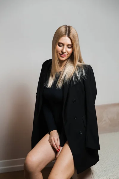 Hermoso glamour mujer de pelo largo posando para fotógrafo de cámara con cuerpo plack con jeans - Retrato en una pared de estudio de fondo sin costuras grises — Foto de Stock