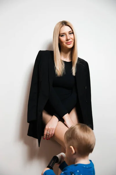 Rubia pelo largo caliente glamour madre jugando con su bebé niño en casa pasar calidad familia valores tiempo — Foto de Stock