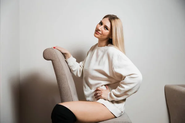 Mulher de cabelo longo glamour bonita posando para fotógrafo câmera vestindo suéter branco no corpo nu - Retrato em uma parede de estúdio de fundo sem costura cinza — Fotografia de Stock