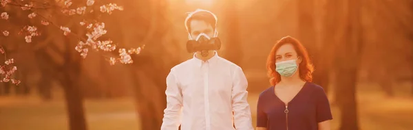 Знамя молодой пары, стоящей в масках в парке — стоковое фото