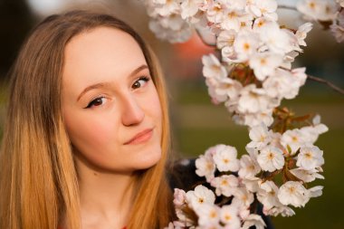 Sakura dalıyla poz veren güzel sarışın kadın.