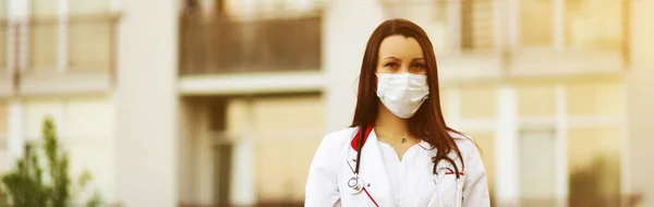 Banner de la joven médica o enfermera en máscara facial quirúrgica en el fondo de la casa — Foto de Stock