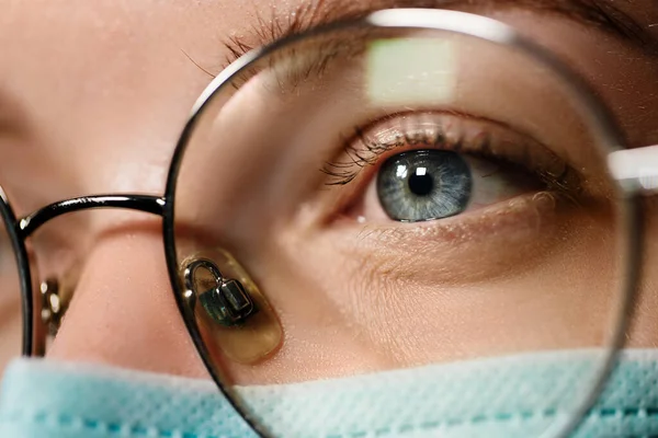 Macro vista del médico en máscara médica mirando hacia otro lado con gafas — Foto de Stock