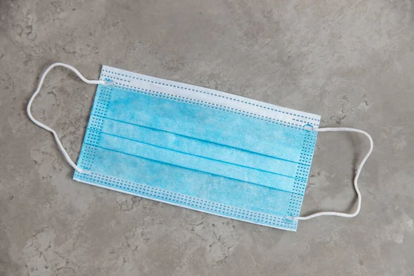 Blue medical face mask on marble table top view — Stock Photo, Image