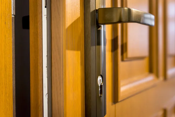 Onderdeel van houten open deur en metalen deurgreep — Stockfoto