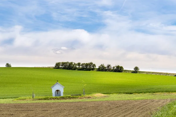 Small chapel in the middle of wavy fields — Stock Photo, Image