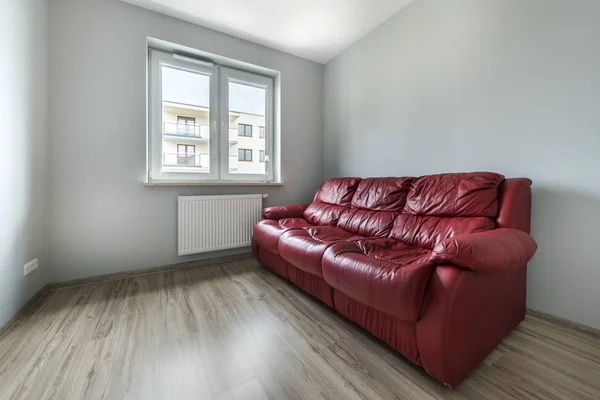 Sofá vermelho no quarto vazio — Fotografia de Stock