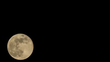 Dolunayın hızlandırılmış hali Dünya 'nın yörüngesindeki karanlık gece gökyüzünde hareket eder.