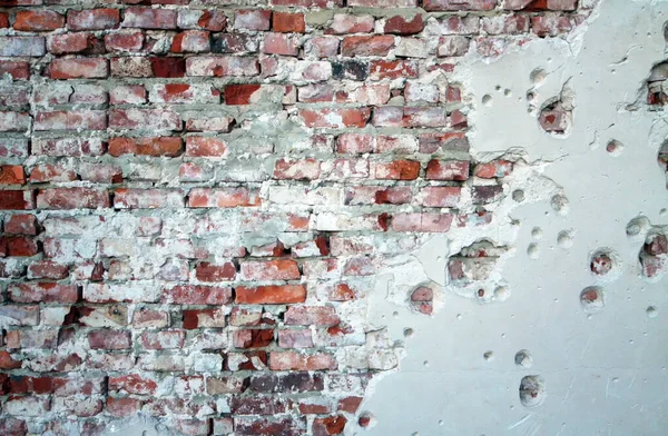 broken brick wall with fragments of plaster