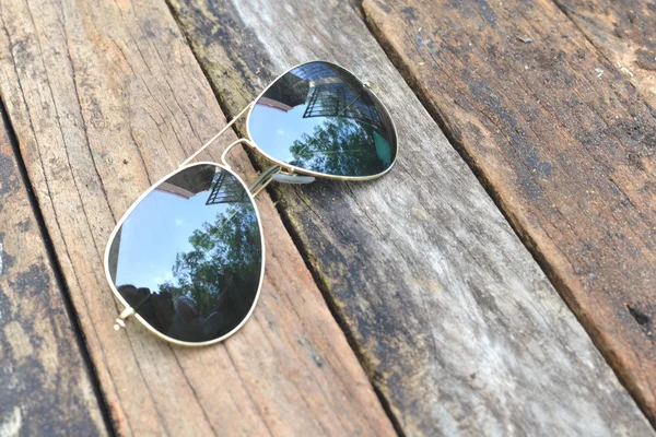 Černé sluneční brýle, které jsou izolovány na dřevo pozadí — Stock fotografie