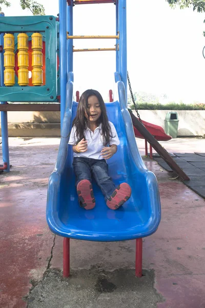 Happy children on slide at playground area — Stock Photo, Image