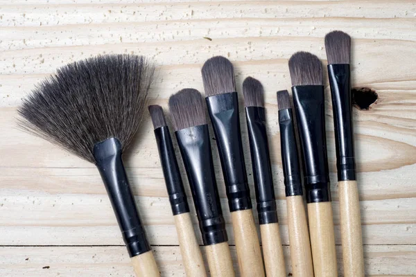 Make up brushes over wooden table — Stock Photo, Image