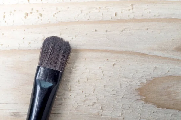Maquiagem escovas sobre mesa de madeira — Fotografia de Stock